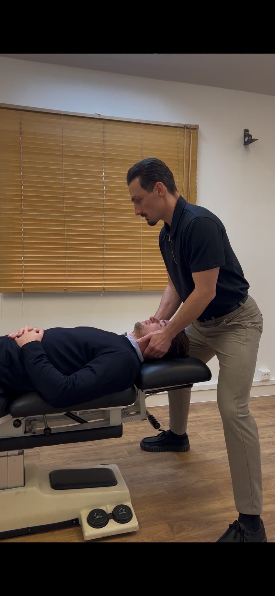 Dr Elliot Ward treating a patient on the table in the clinic